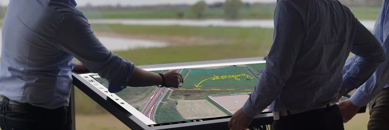 Een team overlegt rond een interactieve kaart op een TouchTable